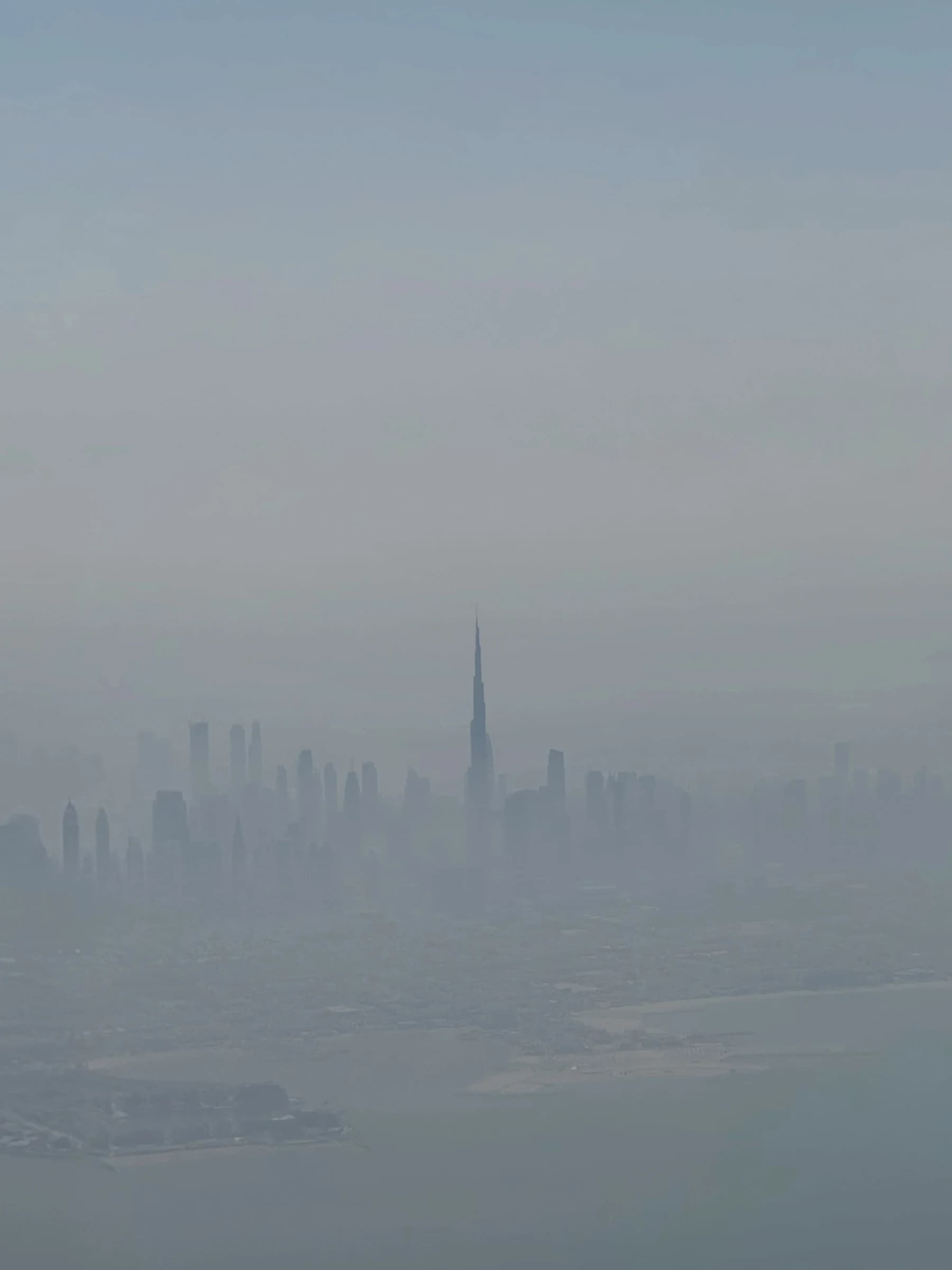 A distant city skyline seen from above through haze