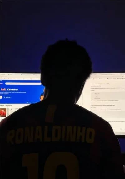 Francis working at his desk with GloboExpats visible on the monitor